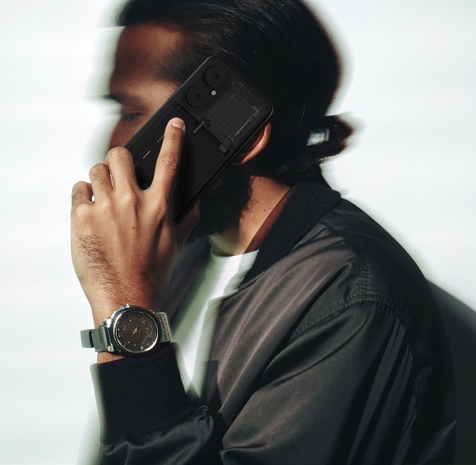 A person holding a BraX3 phone to their ear, transparent back visible